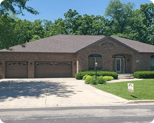 A large brick house with two garage doors.