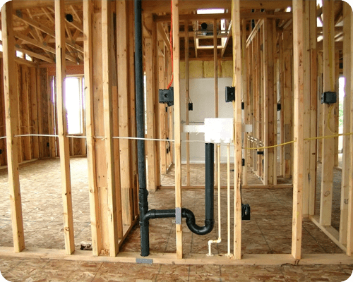 A bathroom with pipes and wires in it