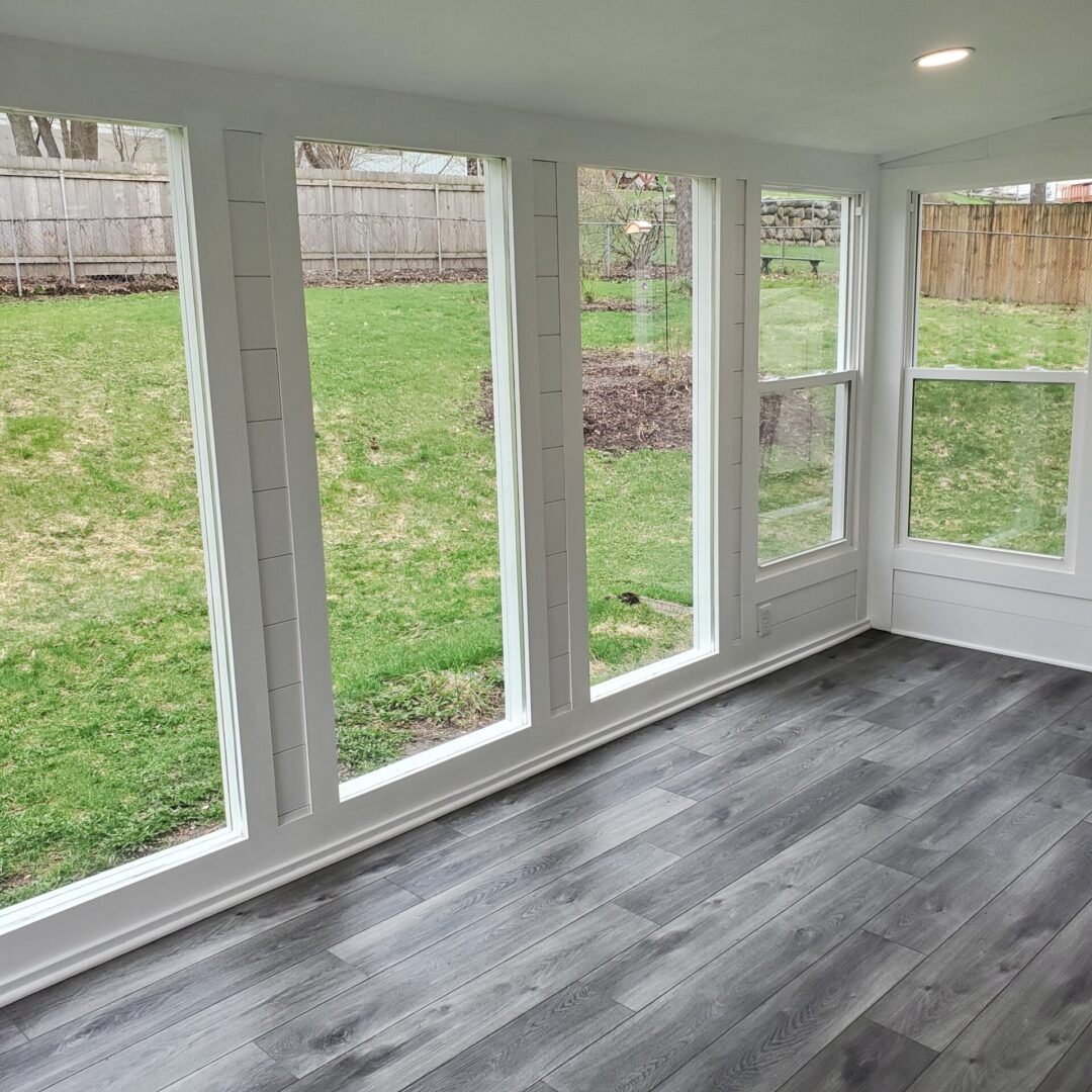 A room with four windows and a wooden floor.