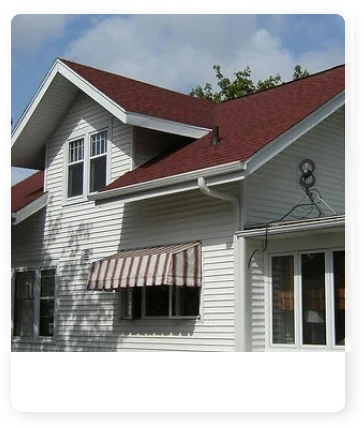 A white house with red roof and awning.