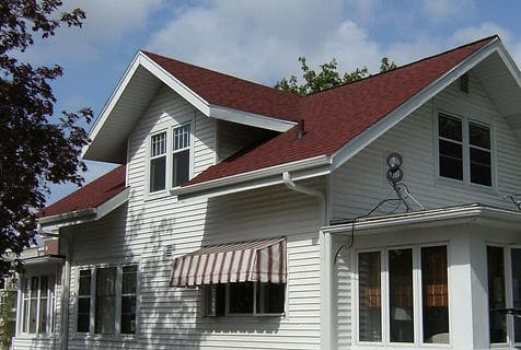 A house with red roof and white siding