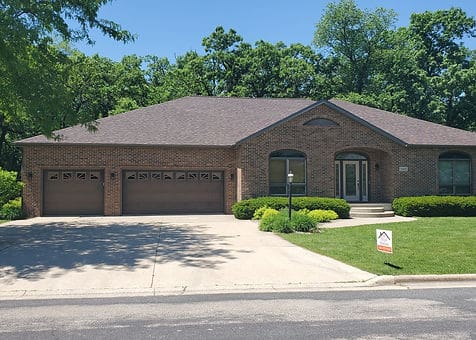 A large brick house with two garage doors.